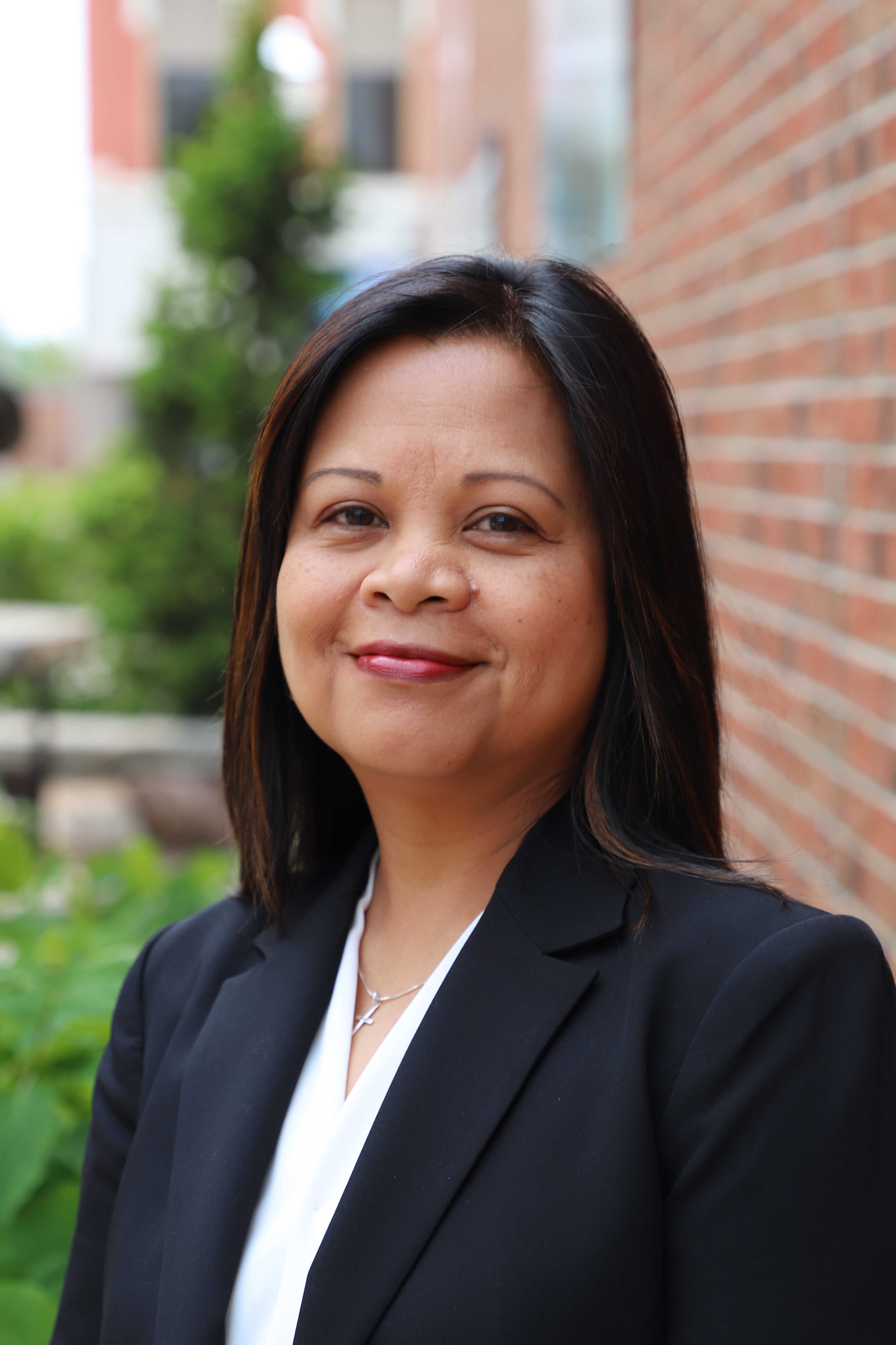 Headshot of Cherry Newlon with tree and brick wall in background